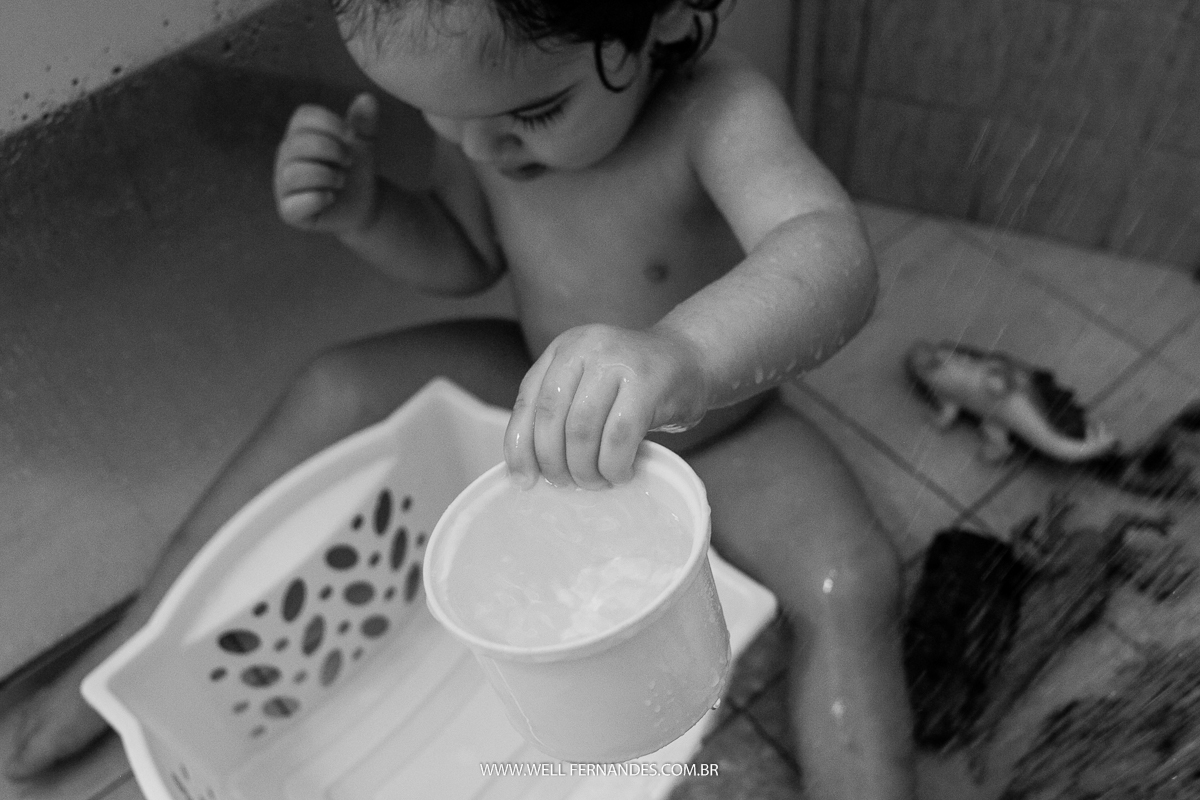 criança brincando em baixo do chuveiro