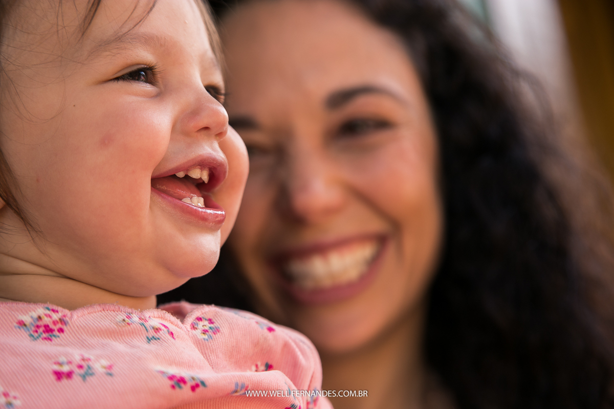 close da meninha sorrindo e sua mae olhando