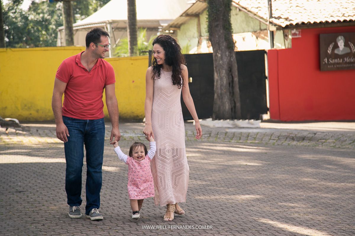 pai e mae de mão dadas com a filha caminhando