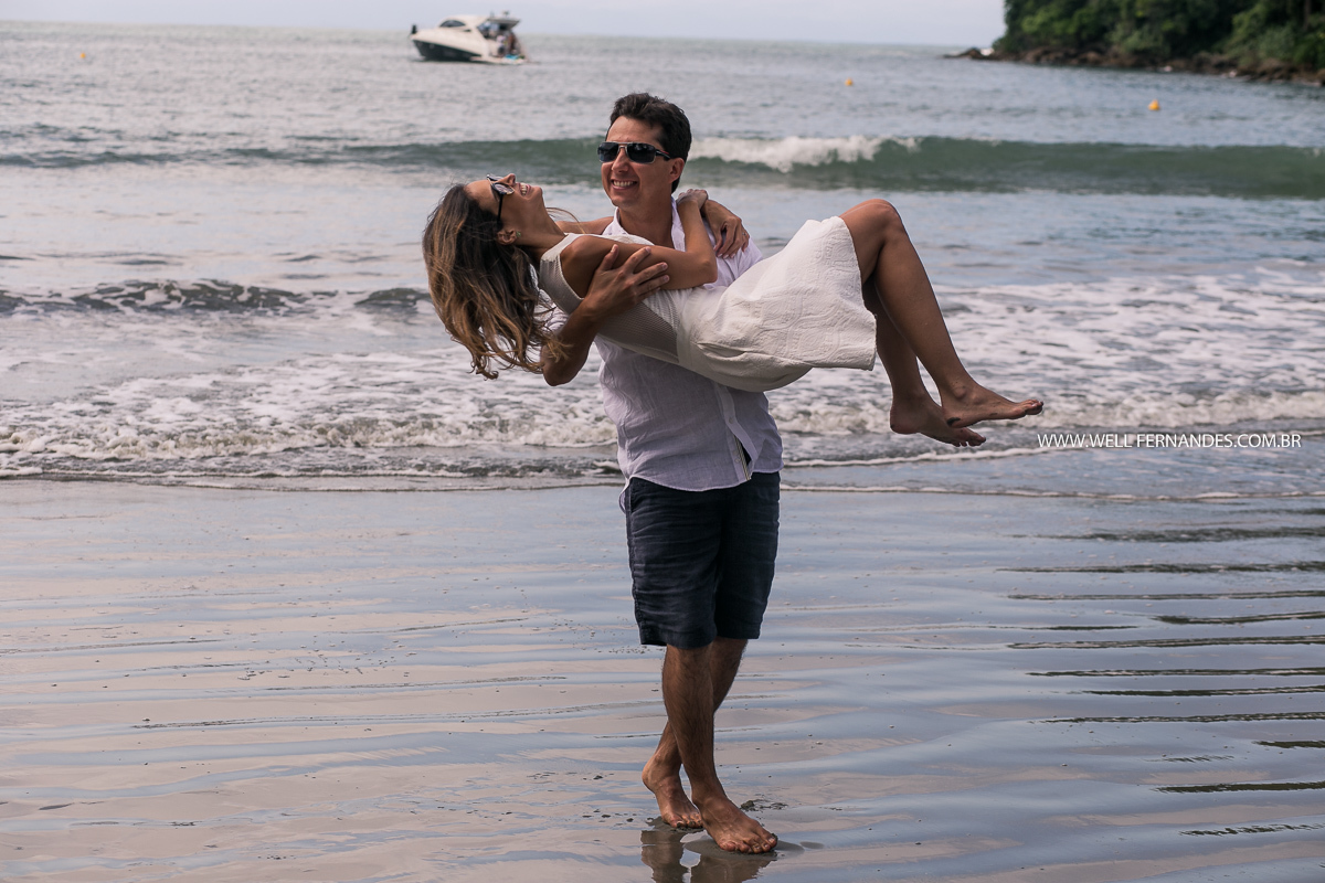 noiva pegando a noiva no colo no ensaio na praia