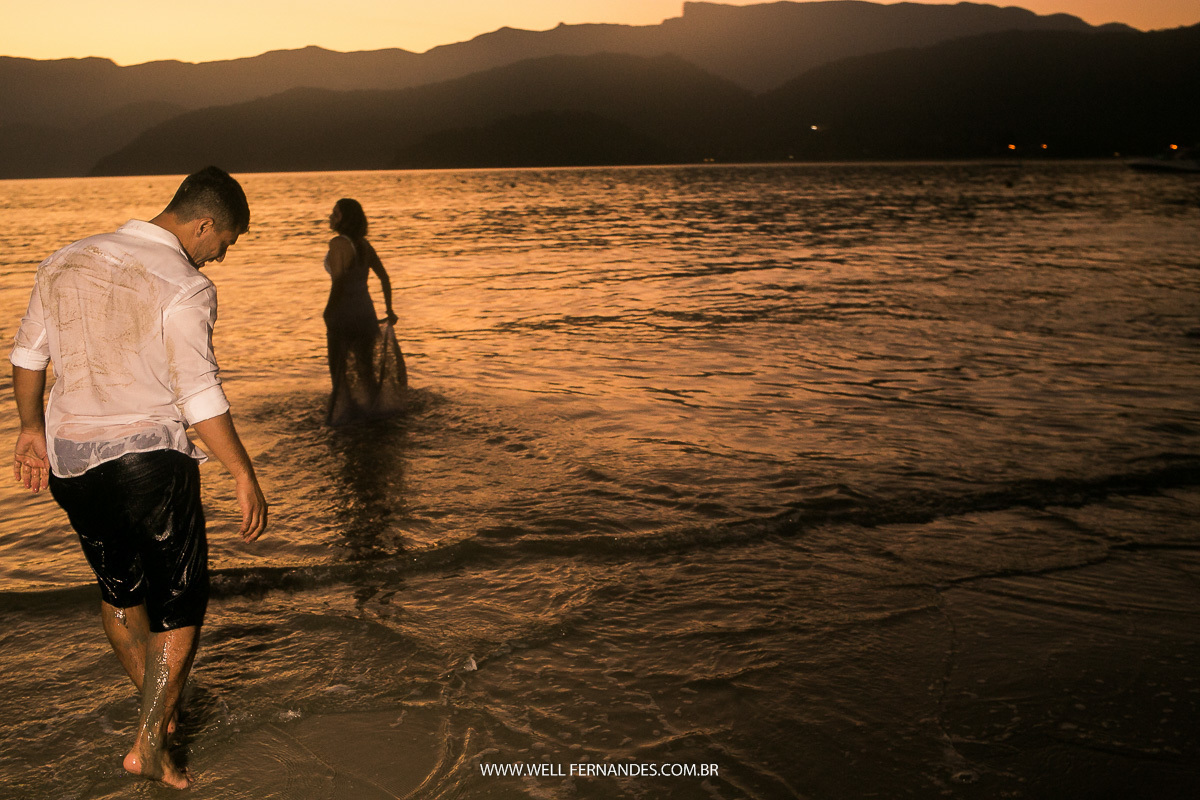 noivos em ensaio dentro do mar