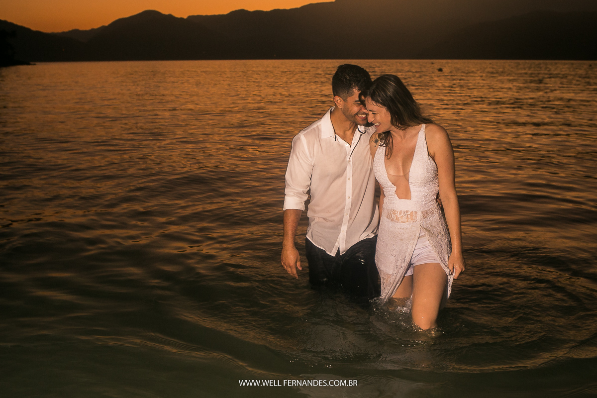 casal molhado se beijando dentro do mar