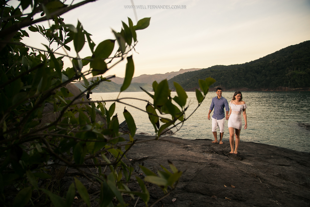 casal caminhando em cima das pedras próximos ao mar