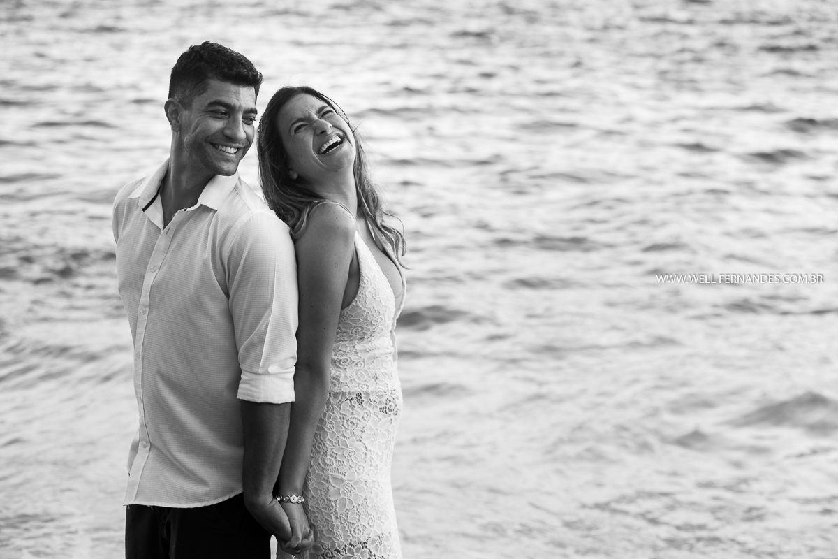 casal sorrindo na beira do mar
