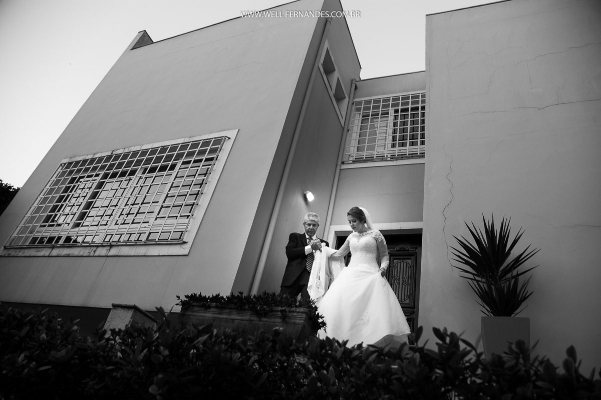 noiva e seu pai saindo da casa para a cerimonia