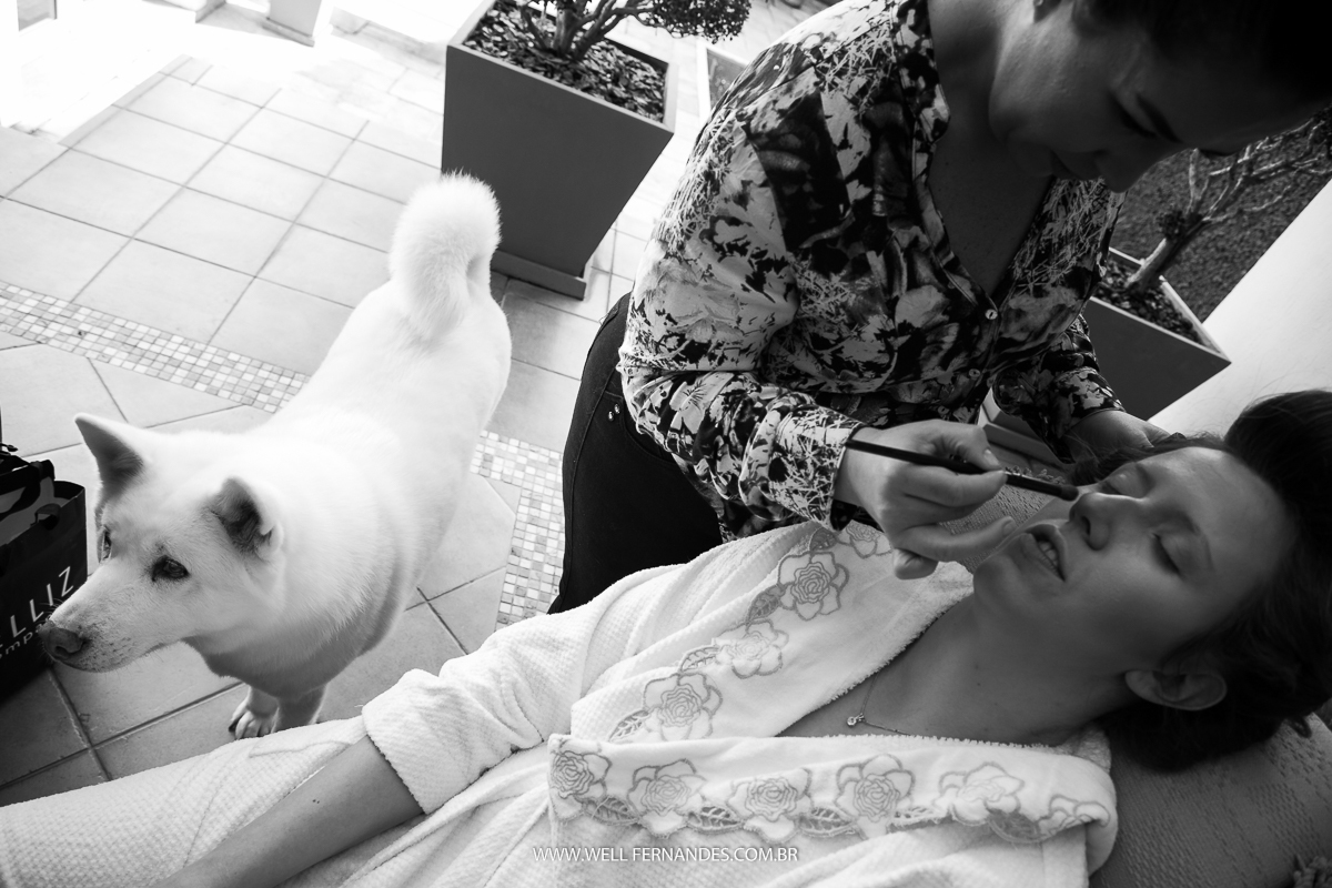 noiva sendo maquiada enquanto o seu cachorro observa
