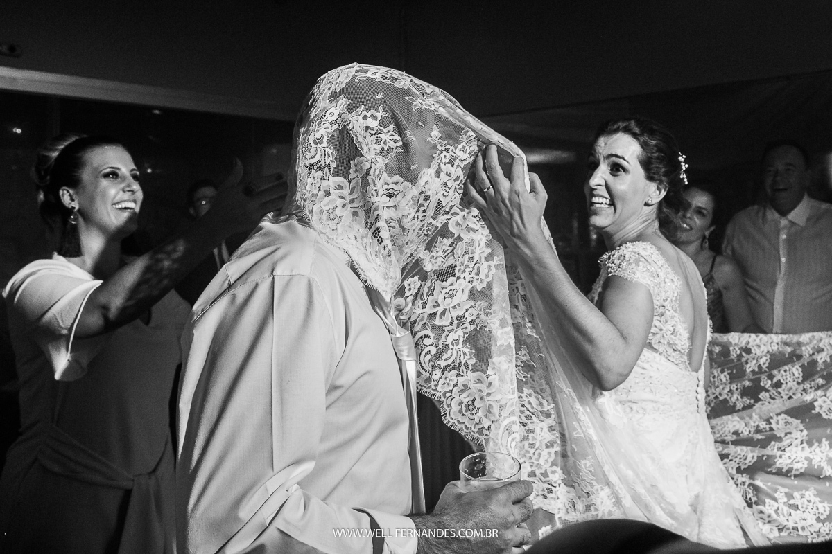 noiva tirando o vestido da cabeça do noivo na festa