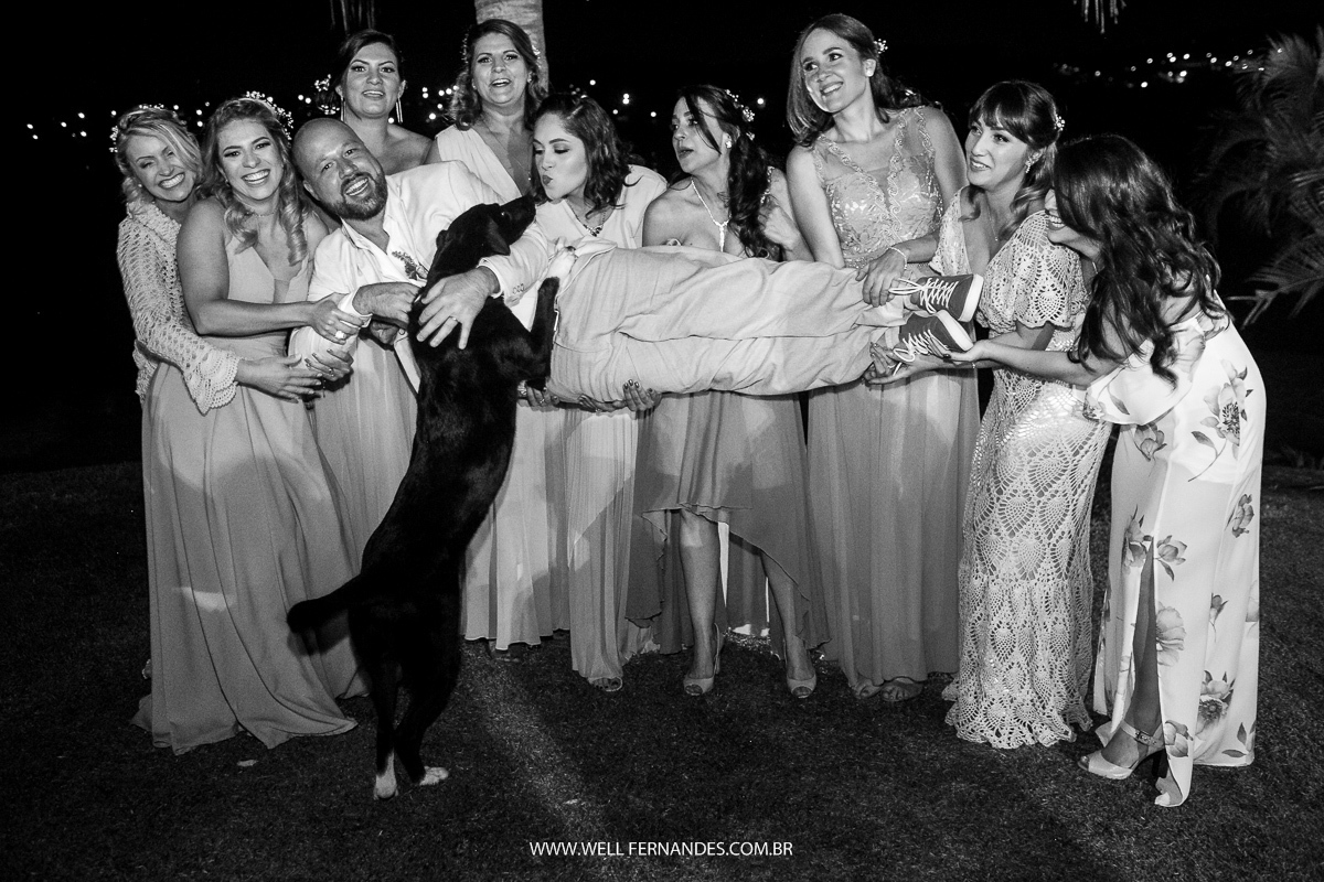 padrinhos levantando no colo o noivo e o cachorro do casal