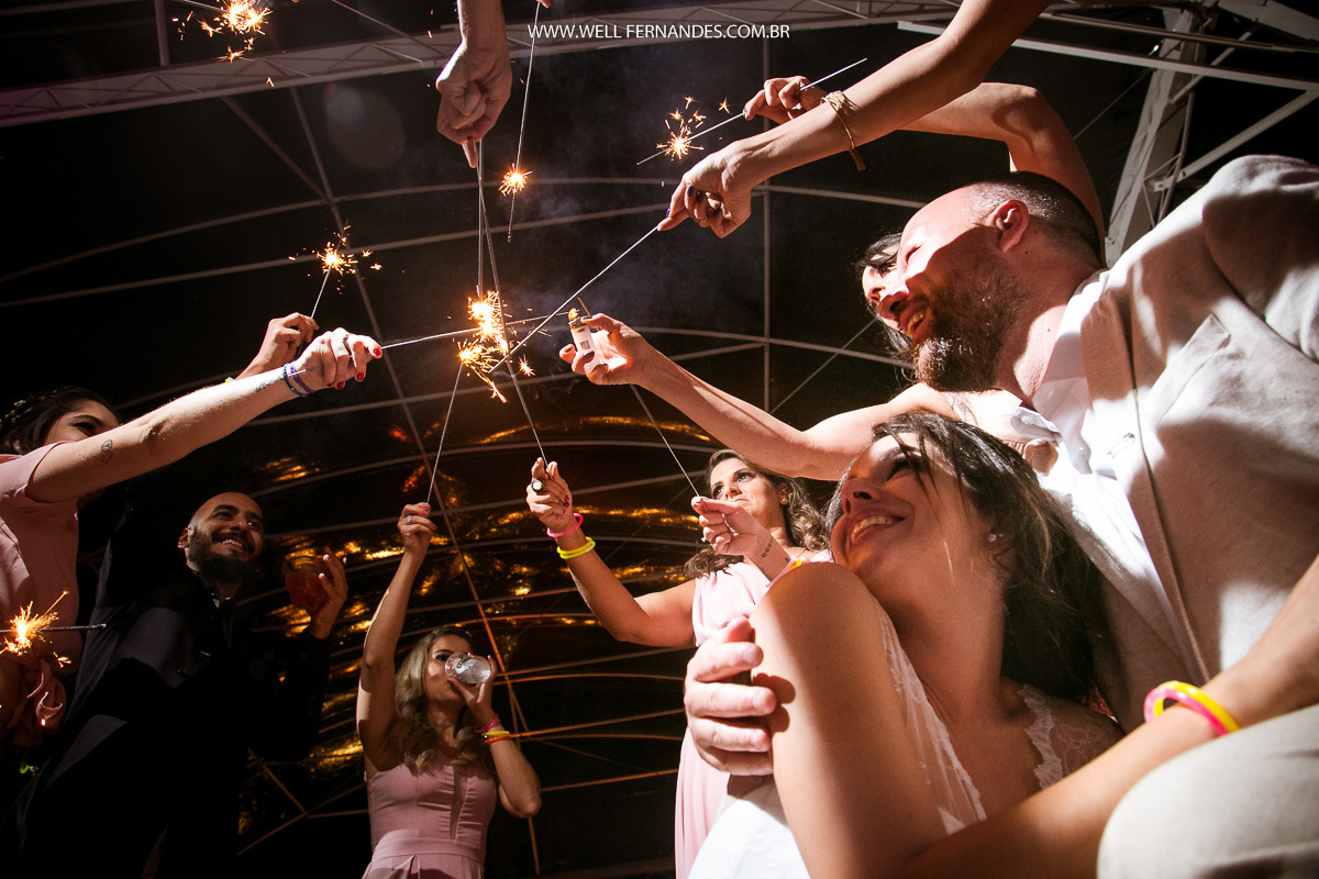 noivos olhando de baixo os padrinhos acendendo os sparkles 