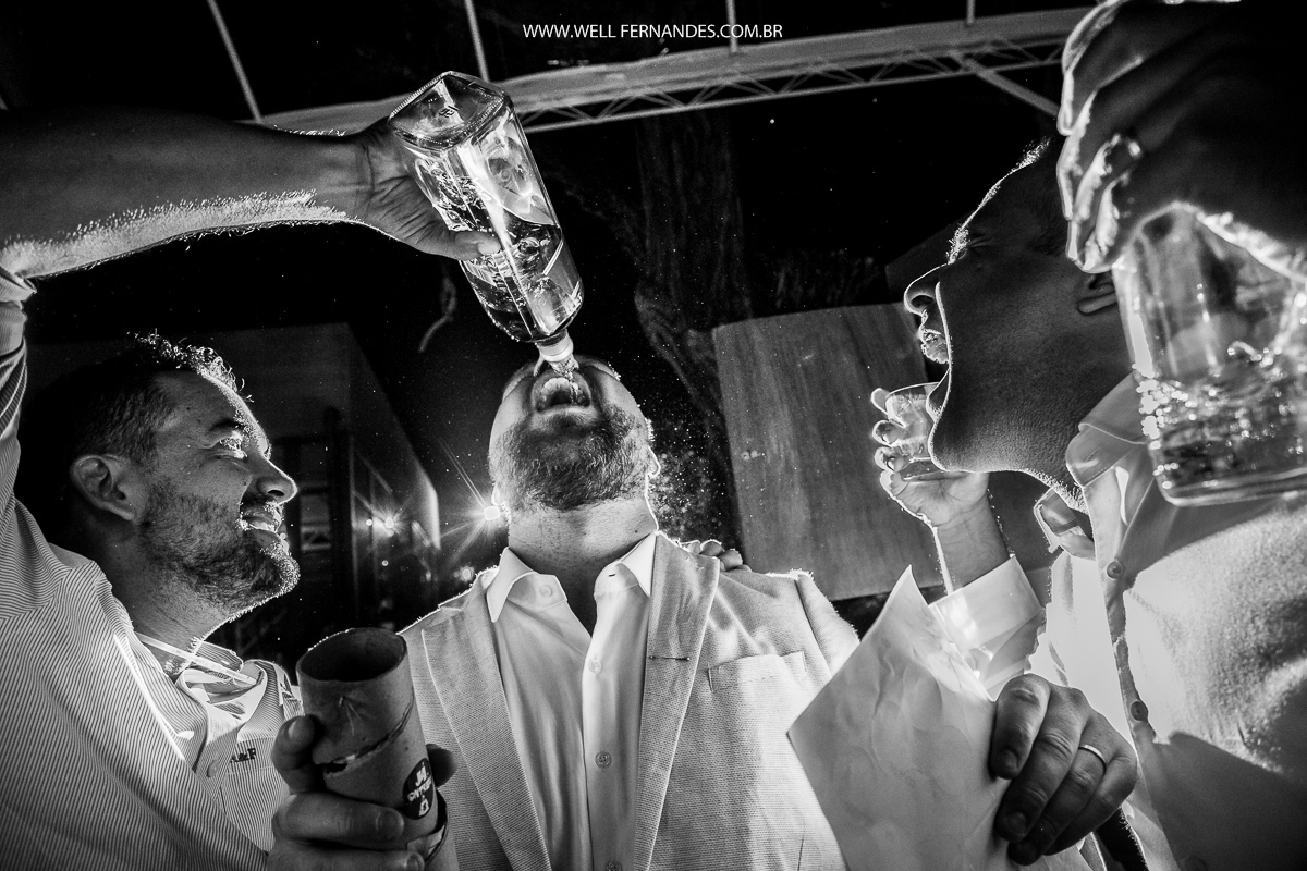 padrinho jogando wisky na boca do noivo