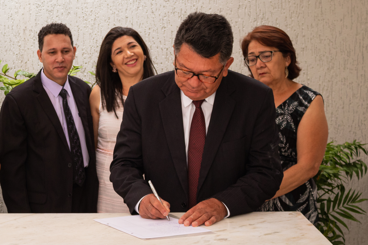 pai da noiva assinando os papéis do casamento