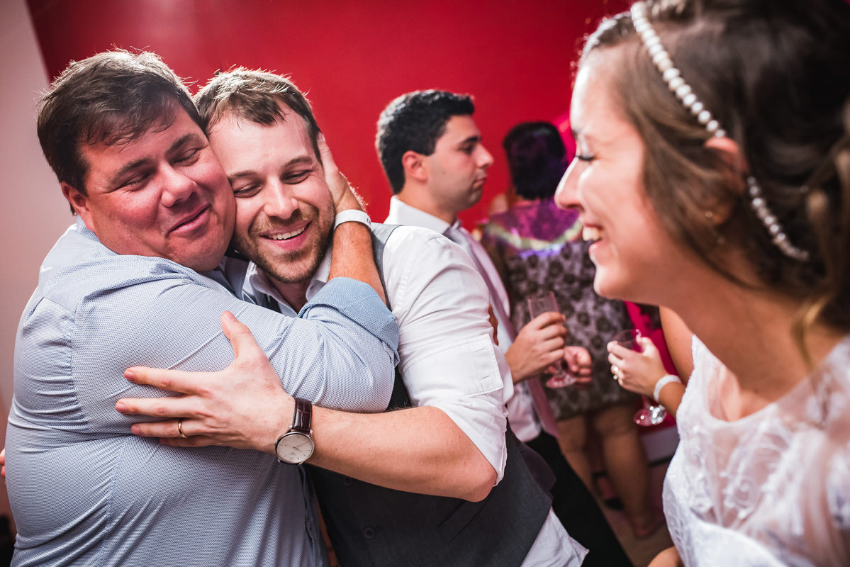 A noiva Karine vendo o abraço emocionado do noivo Pedro em seu amigo, Galeria Scenarium/Rio Scenarium, Rio de Janeiro/RJ