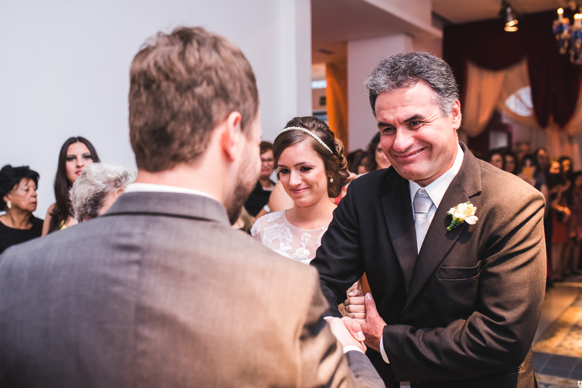 O pai da noiva levando sua filha Karine até o noivo Pedro na cerimônia do casamento na Galeria Scenarium/Rio Scenarium, Rio de Janeiro/RJ
