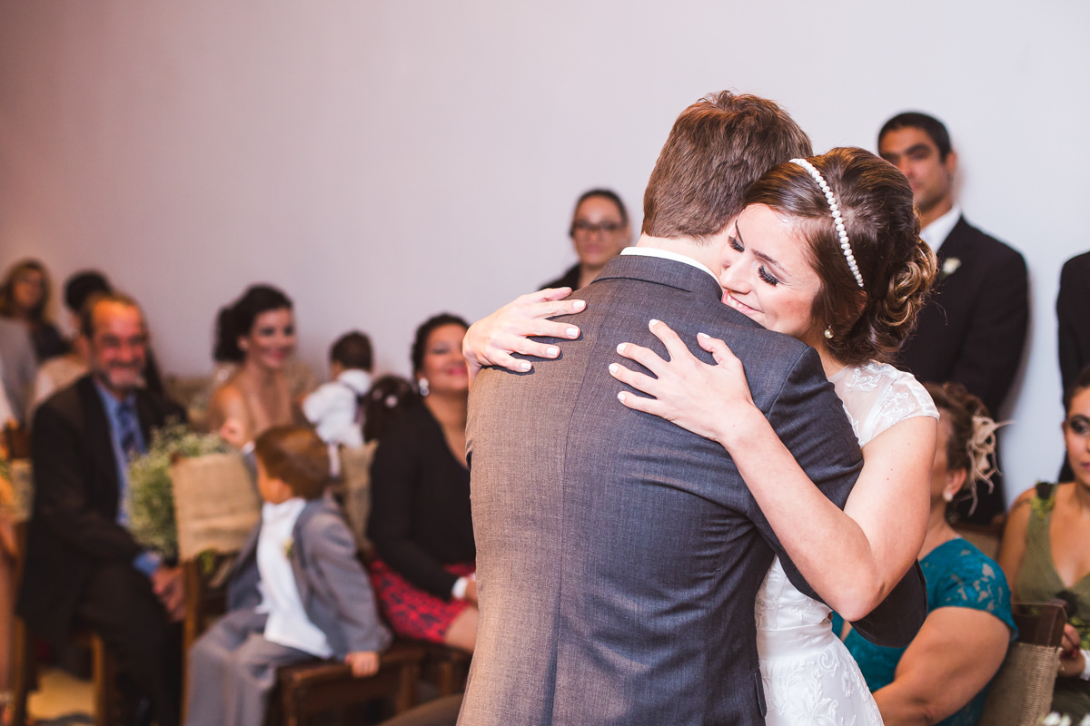Abraço emocionado dos noivos Karine e Pedro na cerimônia do seu casamento na Galeria Scenarium/Rio Scenarium, Rio de Janeiro/RJ