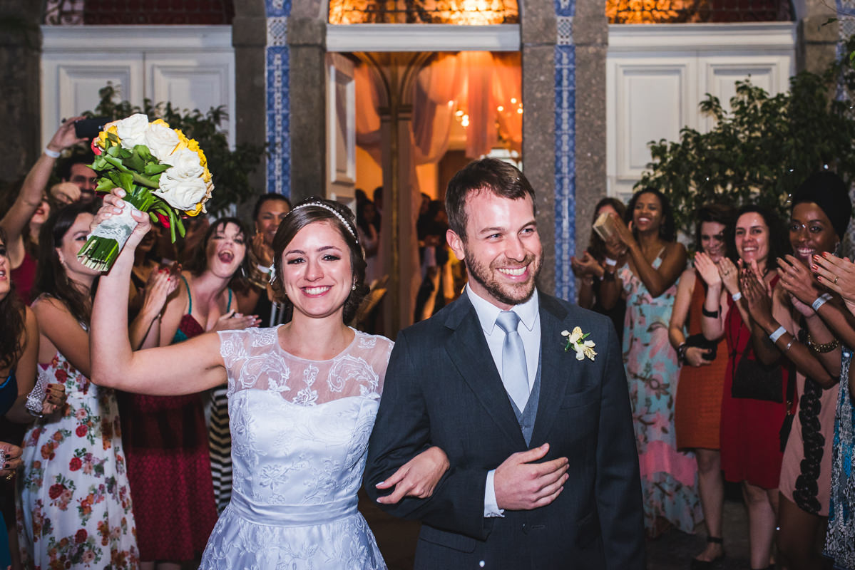 Convidados aplaudindo os noivos Karine e Pedro depois da celebração do casamento na Galeria Scenarium/Rio Scenarium, Rio de Janeiro/RJ