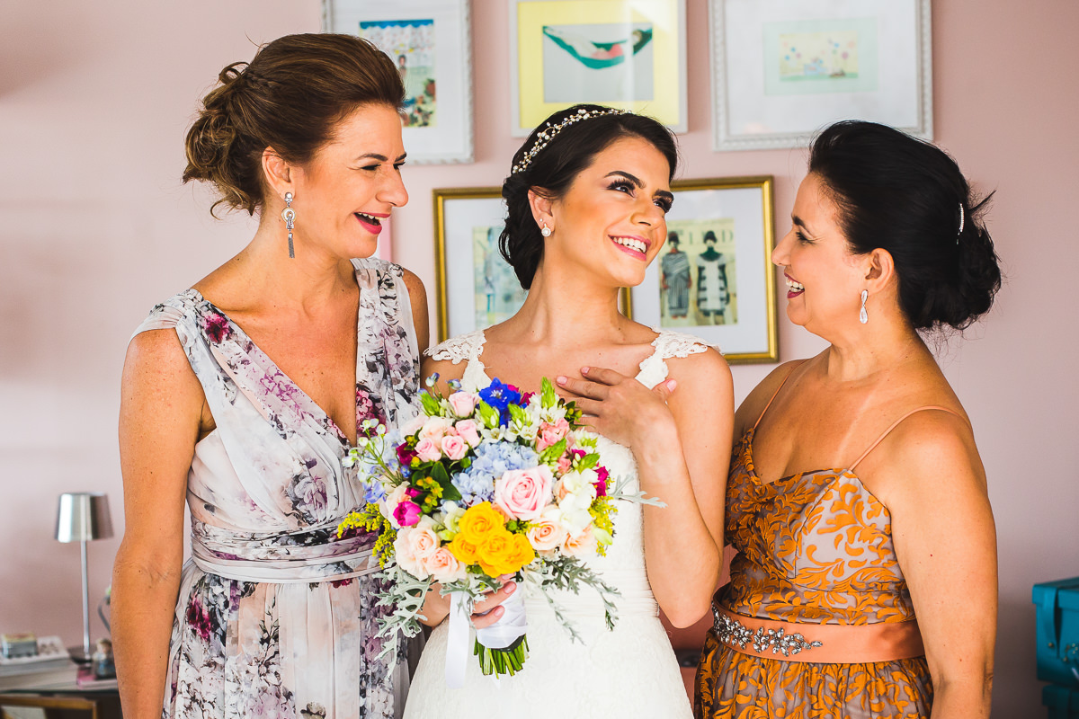 A mãe da noiva e a mãe do noivo felizes com a noiva Mariana no Studio Vênus, Guaratinguetá-SP