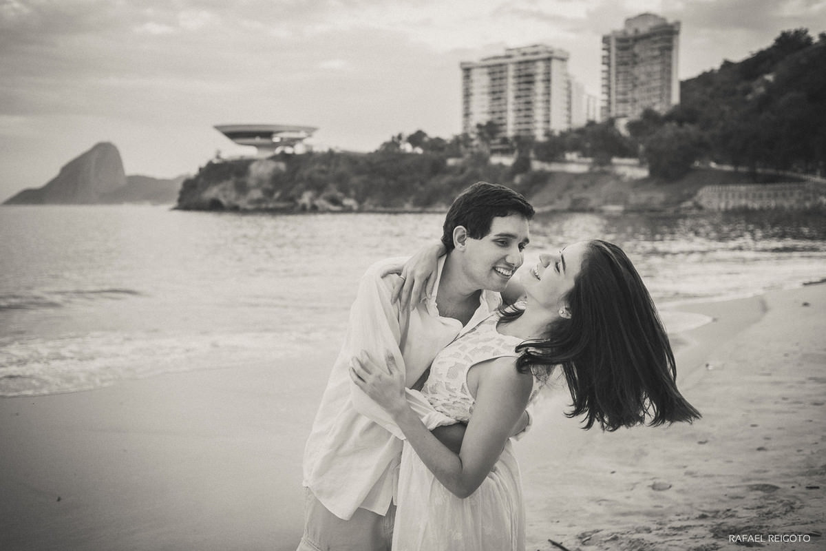 Momento descontraído do casal Mariana e Israel no ensaio pré-casamento na Praia de Icaraí, Niterói/RJ