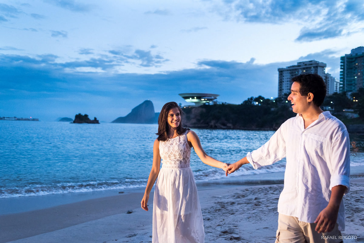 Ensaio do casal Mariana e Israel na Praia de Icaraí com o Museu de Arte Contemporânea iluminado ao fundo, Niterói/RJ