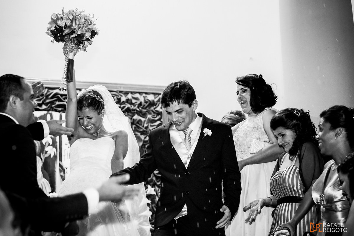 Padrinhos e madrinhas do casamento de Talita e Thiago jogando arroz no casal depois da da cerimônia de casamento no Marista São José, Tijuca, Rio de Janeiro/RJ