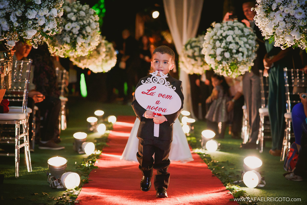 O pajem entrando com a plaquinha na cerimônia do casamento de Priscila e Vitor no Green House Buffet, Ilha do Governador, Rio de Janeiro/RJ