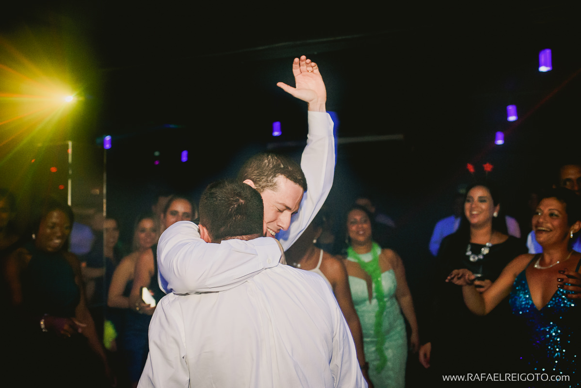 O noivo Vitor abraçando seu amigo na ´pista de dança em seu casamento na Green House Buffet, Ilha do Governador, Rio de Janeiro/RJ