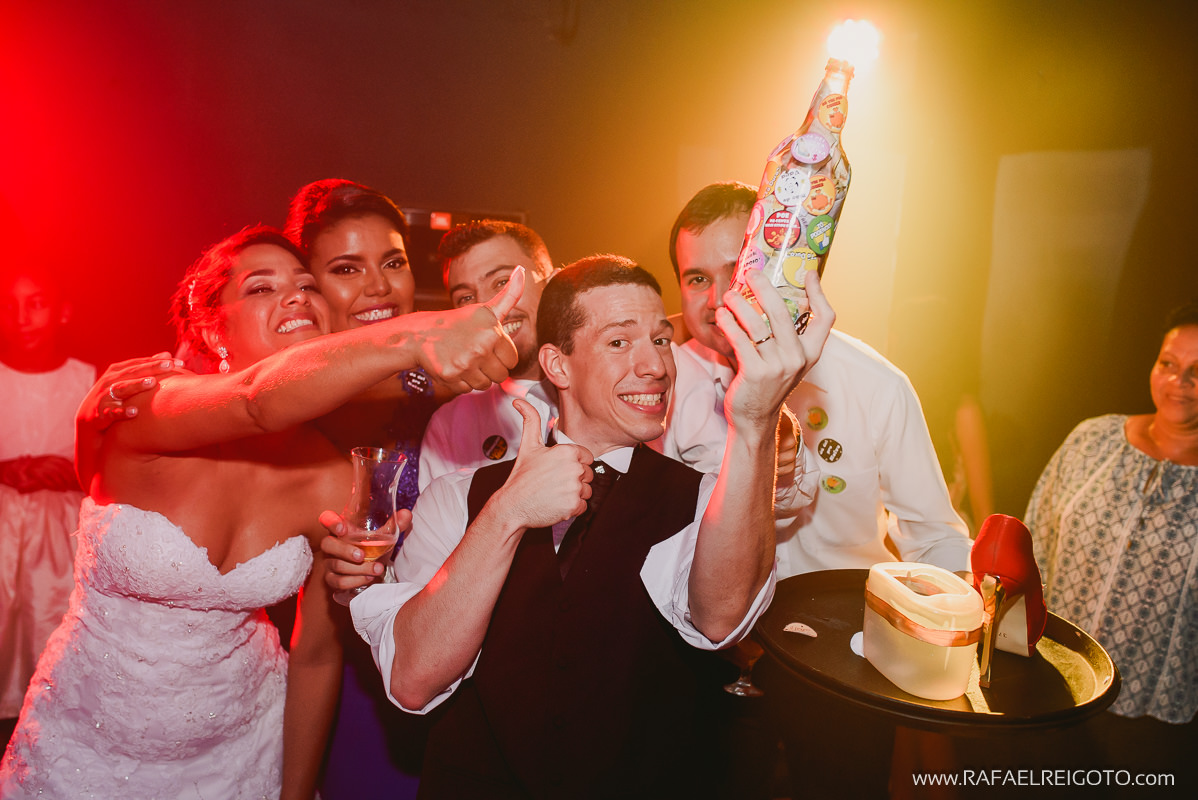 O noivo Vitor segurando a garrafa com o dinheiro que os convidados deram no seu casamento Green House Buffet, Ilha do Governador, Rio de Janeiro/RJ