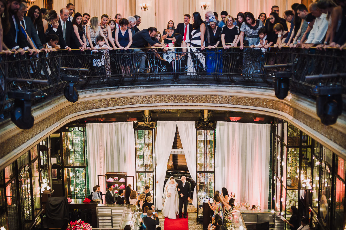 Os convidados olhando a entrada da noiva Débora com seu pai para a cerimônia do seu casamento na Confeitaria Colombo, Centro, Rio de Janeiro-RJ