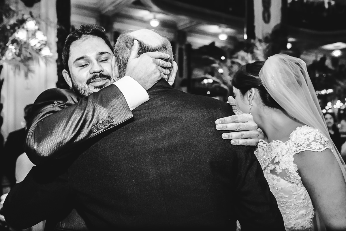 O noivo abraçando o pai da noiva na cerimônia do seu casamento na Confeitaria Colombo, Centro, Rio de Janeiro-RJ