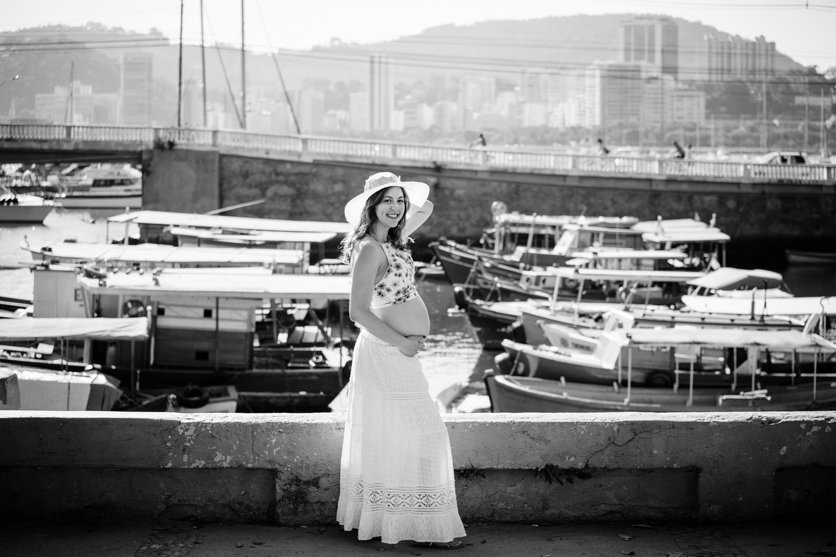 A futura mamãe Verônica vestida de saia longa e chapéu no ensaio gestante na Mureta da Urca, Rio de Janeiro-RJ
