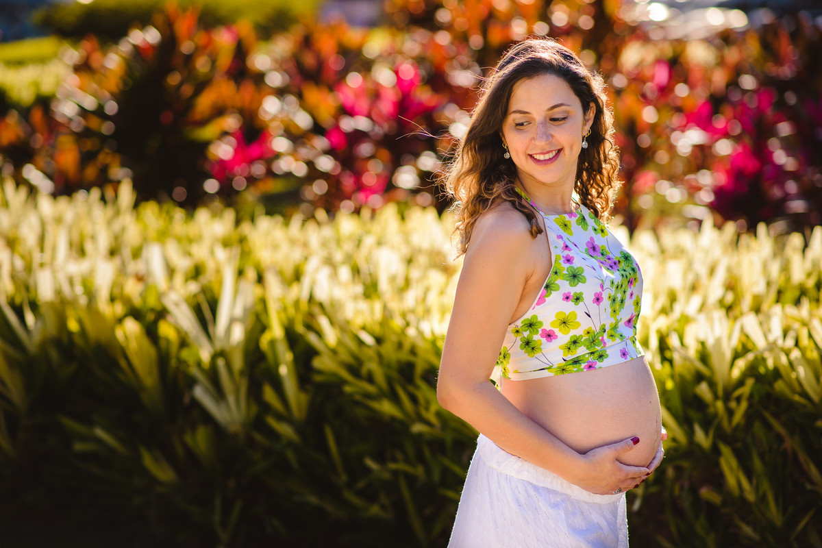 Mamãe Verônica de perfil no ensaio gestante num jardim na Urca, Rio de Janeiro, RJ.