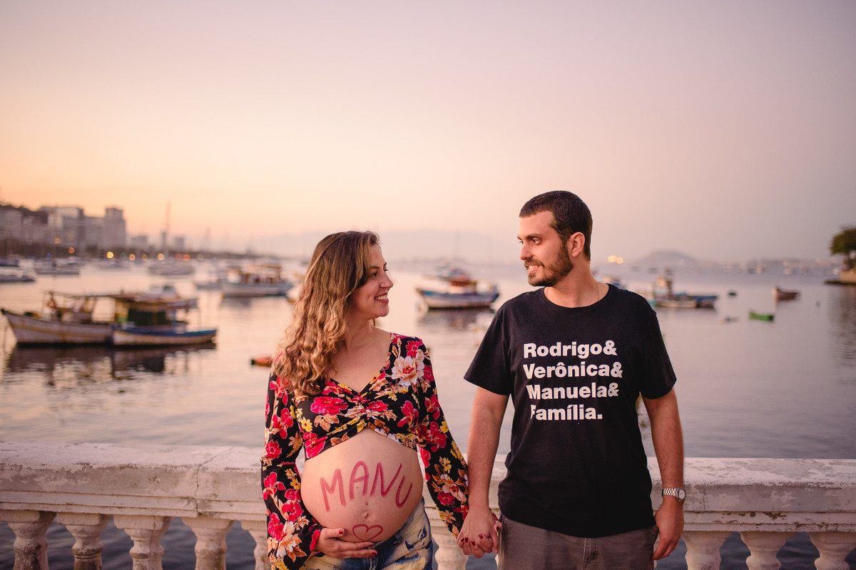 Mamãe Verônica e Papai Rodrigo se entreolhando neste lindo cenário da Mureta da Urca durante o pôr-do-sol no ensaio família.