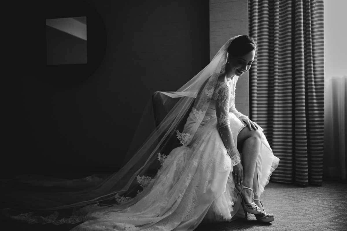 Foto preta e branca da noiva Luana calçando a sandália no making of no Hotel Sheraton, Leblon, Rio de Janeiro-RJ