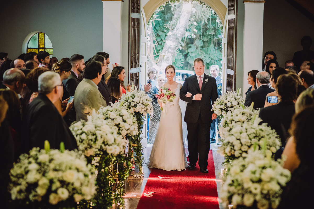 Entrada da noiva Luana com seu pai na cerimônia do seu casamento na Capela Santa Ignez, Gávea, Rio de Janeiro-RJ