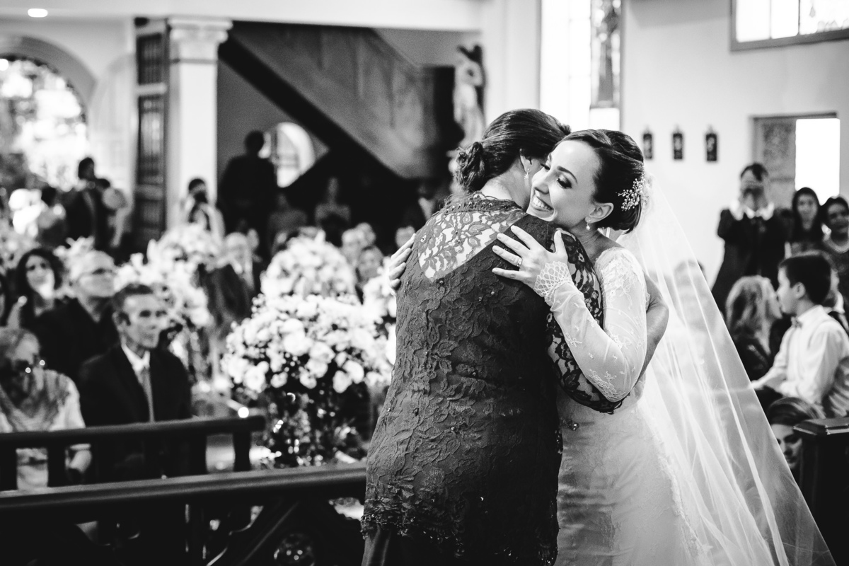 A noiva Luana feliz abraçando sua sogra após a celebração do casamento na Capela Santa Ignez, Gávea, Rio de Janeiro-RJ