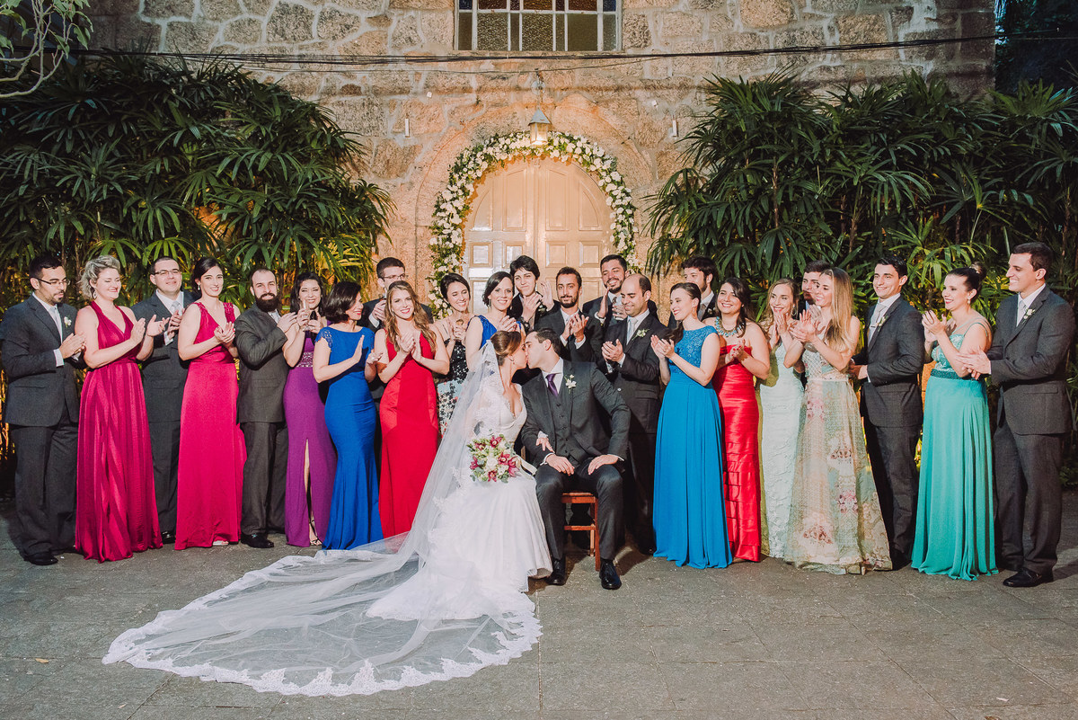 Padrinhos e madrinhas aplaudindo o beijo do casal Luana e Julio em frente a Capela Santa Ignez, Gávea, Rio de Janeiro-RJ.