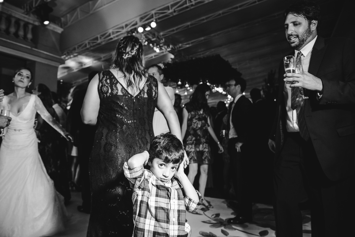 Criança tapando os ouvidos por causa da música alta da banda na festa do casamento de Luana e Julio no salão da Capela Santa Ignez, Gávea, Rio de Janeiro-RJ