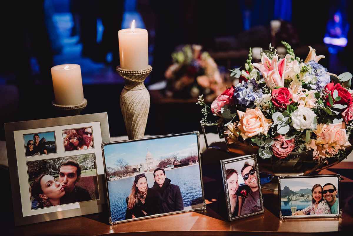 Mesa com fotos dos noivos Luana e Julio na decoração da festa do casamento no salão da Capela Santa Ignez, Gávea, Rio de Janeiro-RJ