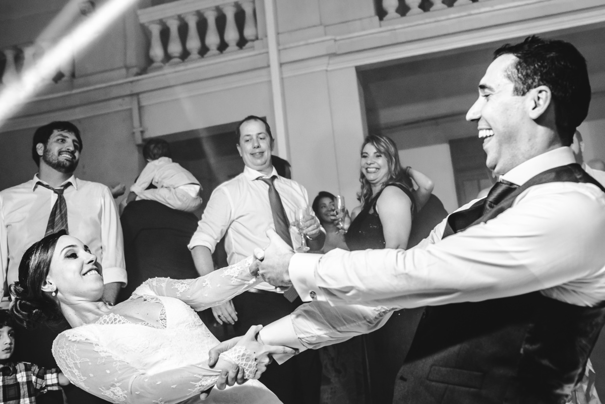 Noivos Luana e Julio descendo até o chão de mãos dadas na festa de seu casamento no salão da Capela Santa Ignez, Gávea, Rio de Janeiro-RJ