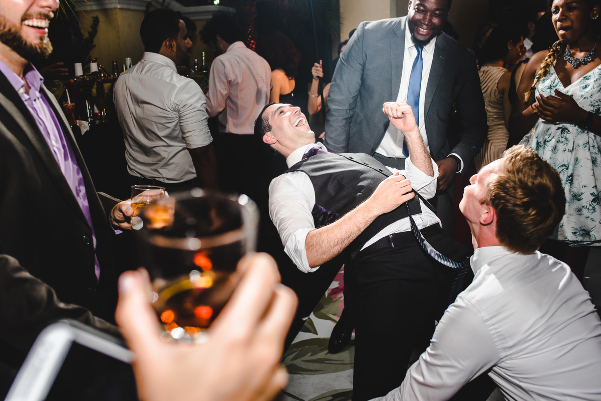 Noivo Julio bem alegre dançando e seu amigo o segurando na pista de dança do seu casamento no salão da Capela Santa Ignez, Gávea, Rio de Janeiro-RJ.