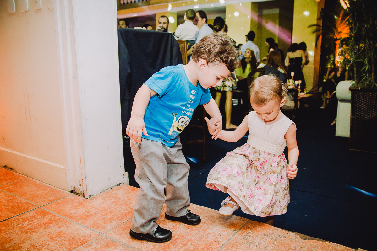 O sobrinho dos noivos ajudando a outra criança a subir o degrau do salão de festas da Capela Santa Ignez no casamento de Luana e Julio, Gávea, Rio de janeiro-RJ.