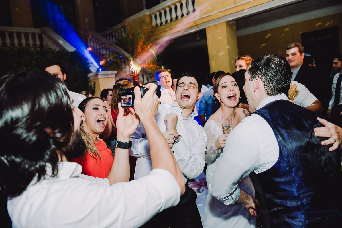 Convidada fotografando com o celular o casal Luana e Julio e seus amigos  na pista de dança do casamento no salão da Capela Santa Ignez, Gávea, Rio de Janeiro-RJ.