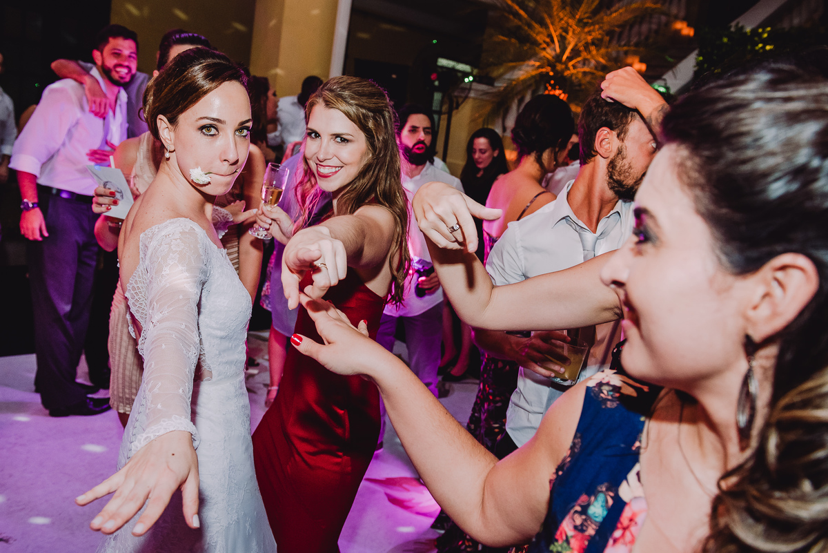 Noiva Luana com uma flor na boca dançando Sidney Magal na festa de seu casamento no  salão da Capela Santa Ignez, Gávea, Rio de Janeiro-RJ.