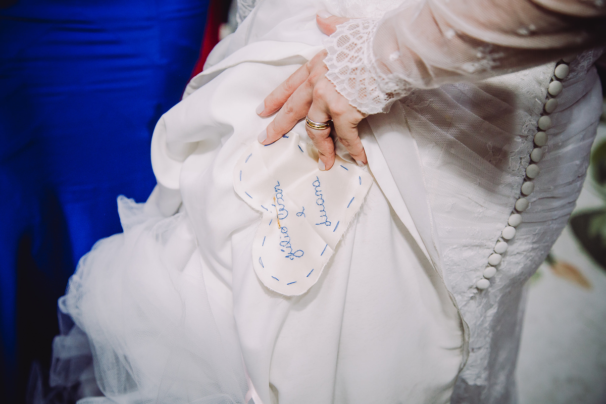 Noiva Luana mostrando o coração colado na barra do vestido com o seu nome e do seu noivo na  festa de seu casamento no  salão da Capela Santa Ignez, Gávea, Rio de Janeiro-RJ.