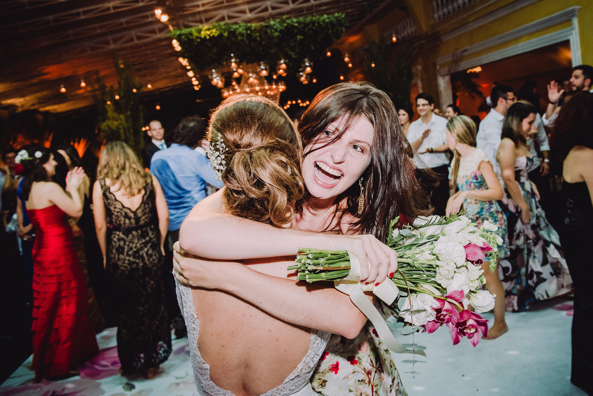 Convidada que pegou o buquê muito feliz abraçando a noiva Luana na  festa de seu casamento no  salão da Capela Santa Ignez, Gávea, Rio de Janeiro-RJ.