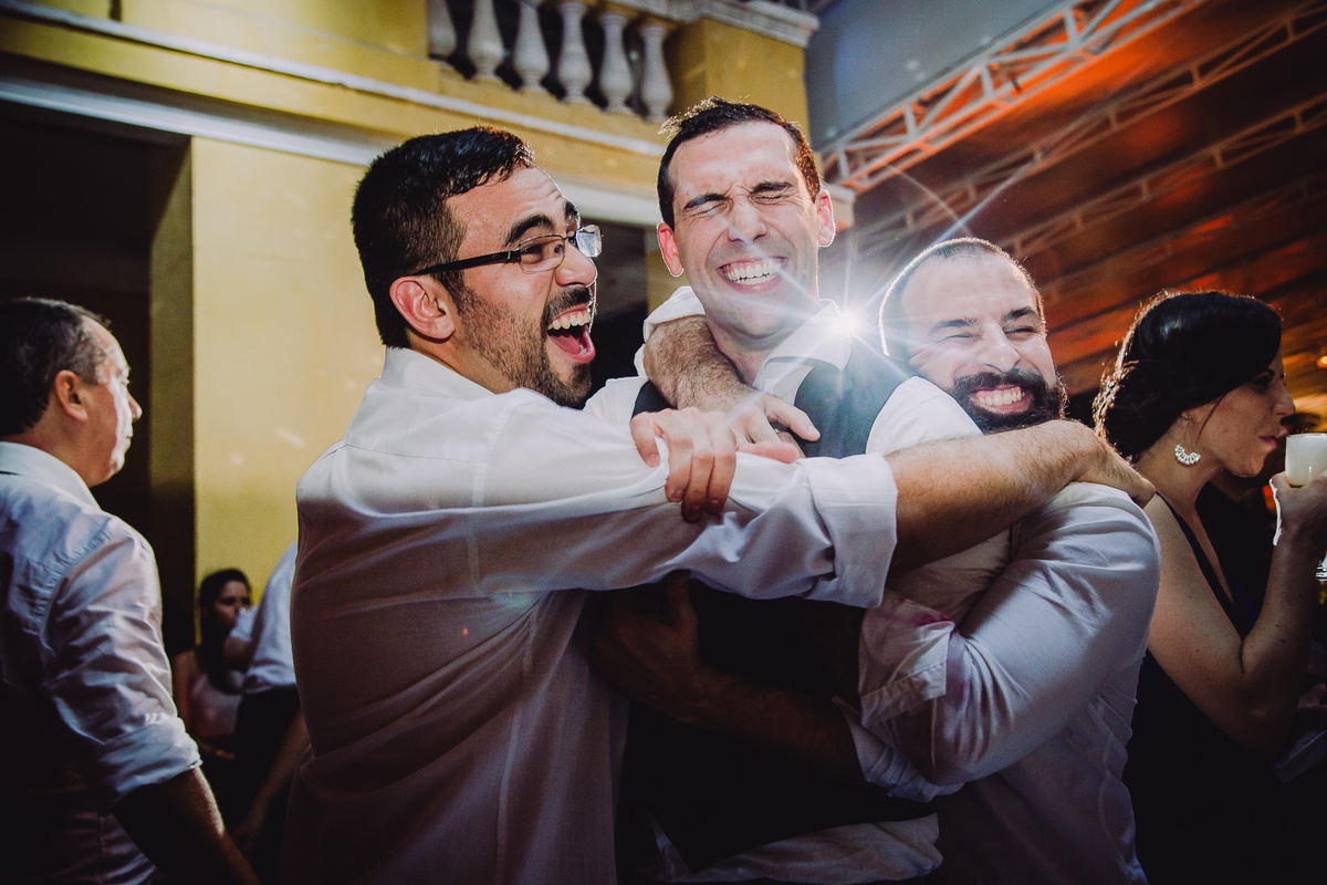Noivo Julio sendo abraçado pelos seus amigos  na festa de seu casamento no salão da Capela Santa Ignez, Gávea, Rio de Janeiro-RJ. 