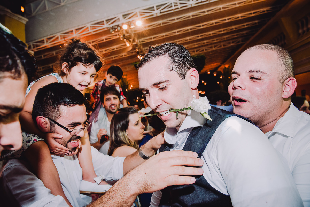 Noivo Julio com uma rosa branca na boca dançando Sidney Magal na festa de seu casamento no salão da Capela Santa Ignez, Gávea, Rio de Janeiro-RJ. 