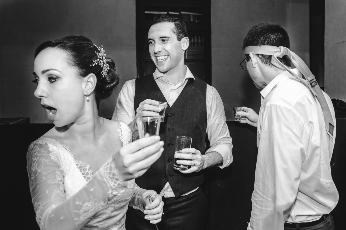 Noiva Luana assustada ao ver que jogou a bebida sem querer na amiga que estava atrás, enquanto o noivo Julio ria da situação na festa de seu casamento no  salão da Capela Santa Ignez, Gávea, Rio de Janeiro-RJ.