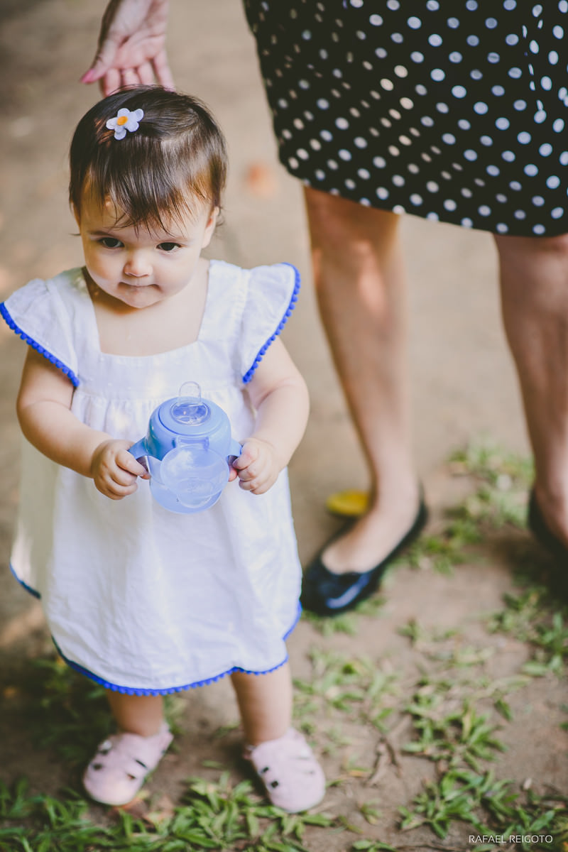 A bebê Catarina com sua mamadeira para lá e para cá no ensaio infantil no Parque Lage, Rio de Janeiro-RJ