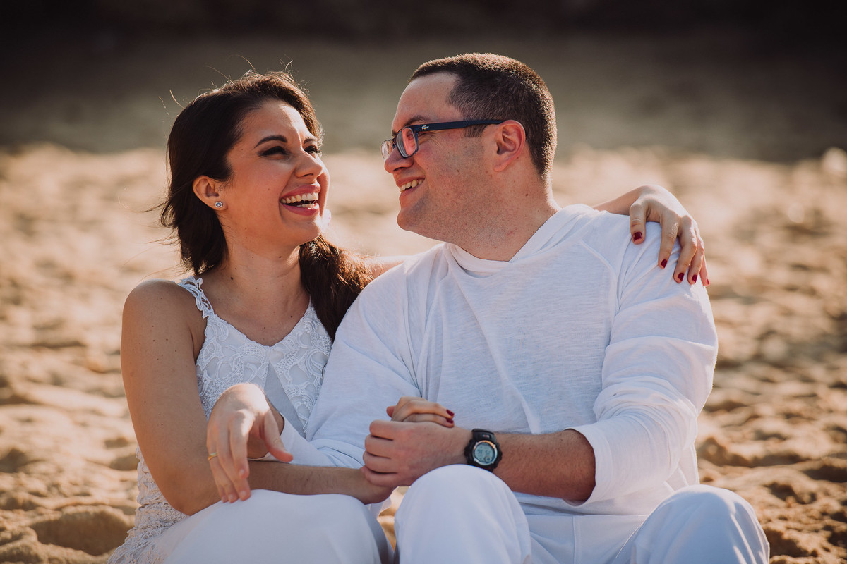 O casal de médicos Bruna e Raphael sorridentes no ensaio pré-casamento na Praia Vermelha, Rio de Janeiro-RJ