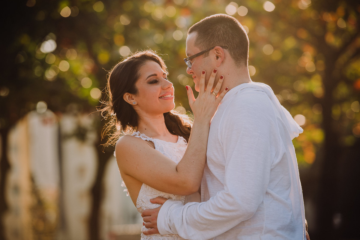 A noiva Bruna fazendo carinho no rosto do seu noivo Raphael no ensaio pré-casamento no bairro da Urca, Rio de Janeiro/RJ